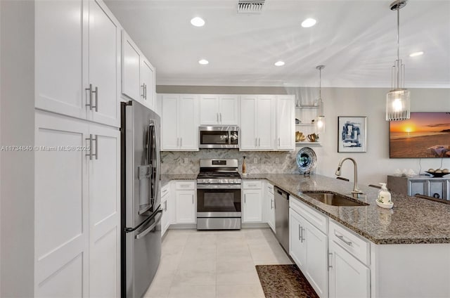 kitchen featuring sink, decorative light fixtures, kitchen peninsula, stainless steel appliances, and white cabinets