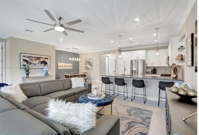 living room with ornamental molding and ceiling fan