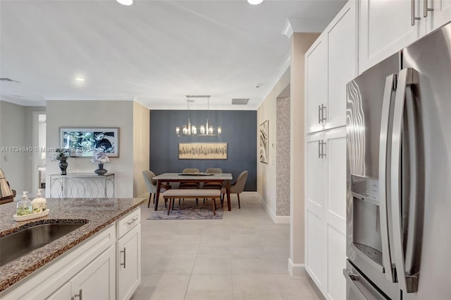 13597 SW Oceanus Blvd, Port St Lucie, FL 34987 - kitchen with stainless steel refrigerator with ice dispenser, crown molding, stone countertops, a chandelier, and white cabinetry