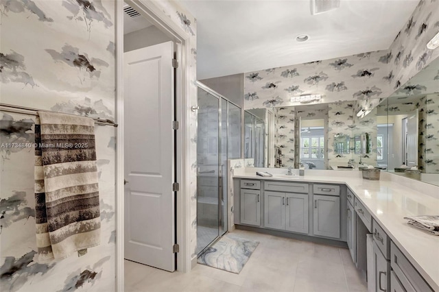full bathroom with wallpapered walls, a shower stall, vanity, and tile patterned floors