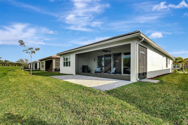 back of house with a patio area, ceiling fan, a lawn, and stucco siding
