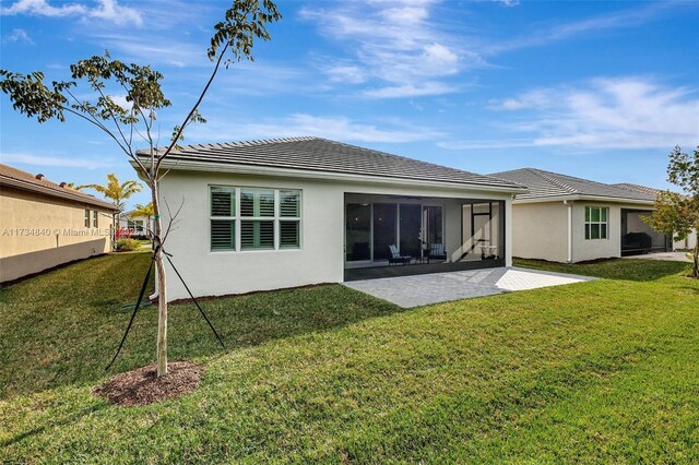 13597 SW Oceanus Blvd, Port St Lucie, FL 34987 - back of property with a patio area, stucco siding, a yard, and a tile roof