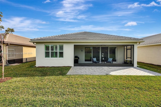 rear view of house with a lawn, a patio, stucco siding, and a ceiling fan