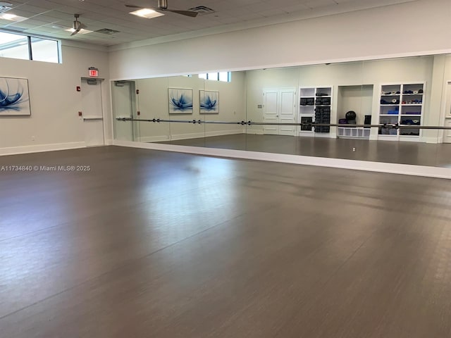 exercise room with hardwood / wood-style flooring and a paneled ceiling