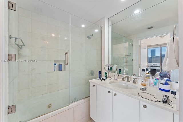 bathroom with vanity and combined bath / shower with glass door