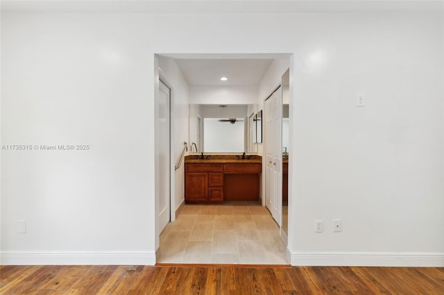 hallway featuring sink and light hardwood / wood-style flooring