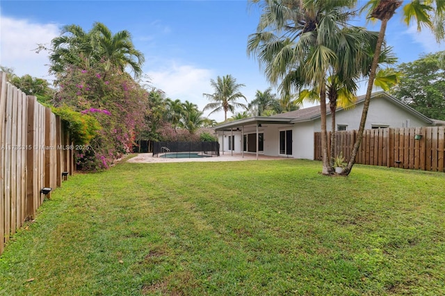 view of yard with a fenced in pool and a patio