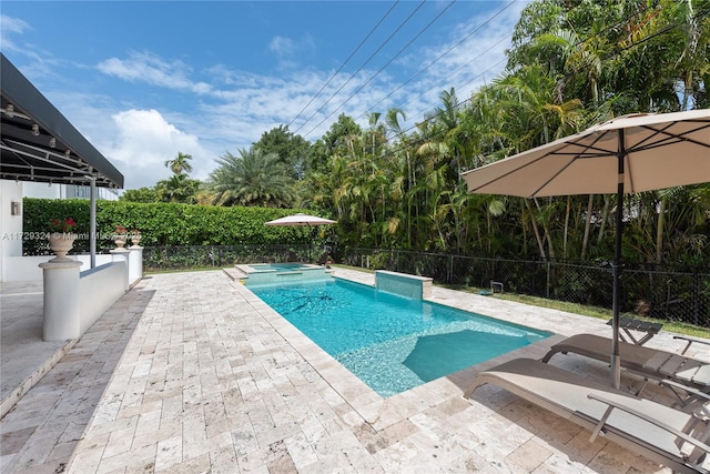 view of swimming pool featuring a patio area and an in ground hot tub