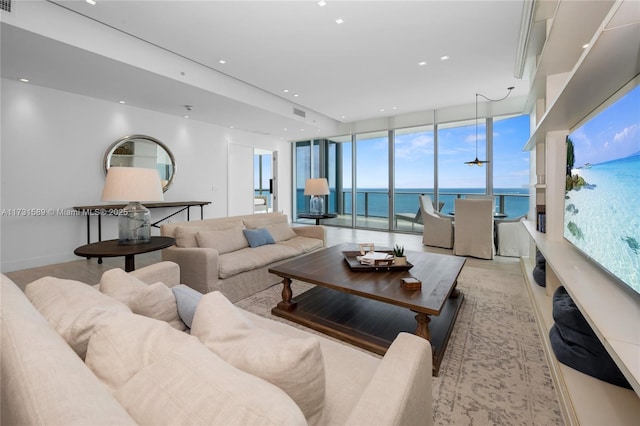 living room featuring floor to ceiling windows and a water view