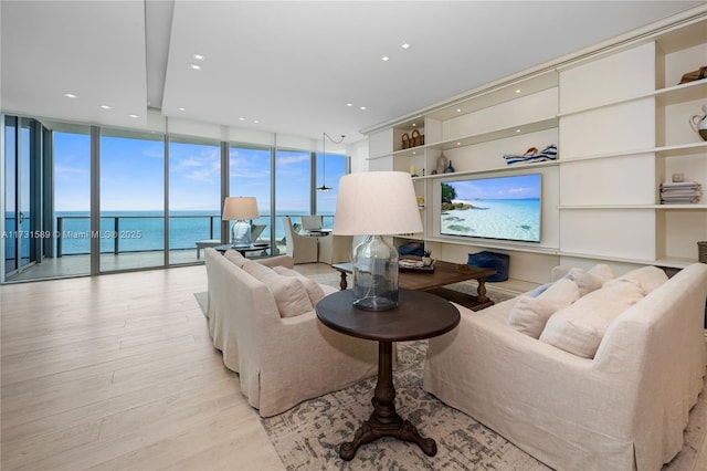 living room with floor to ceiling windows and light hardwood / wood-style flooring