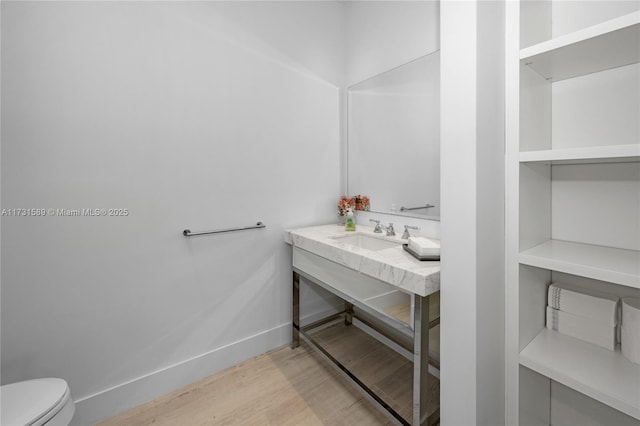 bathroom with hardwood / wood-style flooring, toilet, and sink