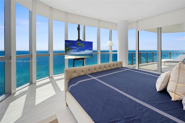 bedroom with floor to ceiling windows and multiple windows