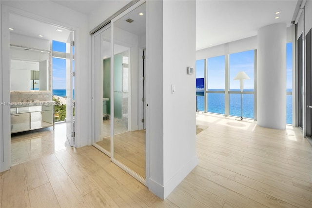 hallway featuring a water view and light wood-type flooring