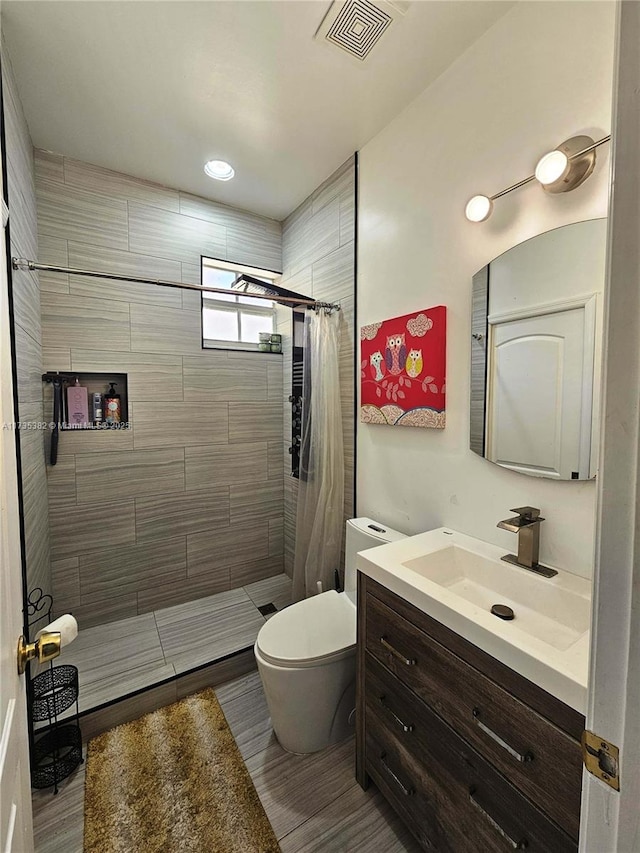 bathroom featuring vanity, curtained shower, and toilet