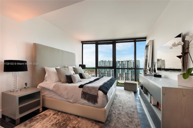 bedroom featuring expansive windows and dark hardwood / wood-style floors