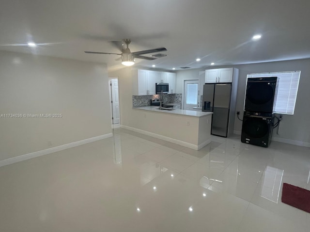 kitchen with appliances with stainless steel finishes, white cabinets, backsplash, ceiling fan, and kitchen peninsula