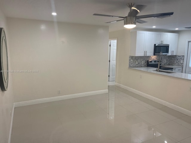 kitchen featuring sink, light tile patterned floors, appliances with stainless steel finishes, white cabinetry, and decorative backsplash