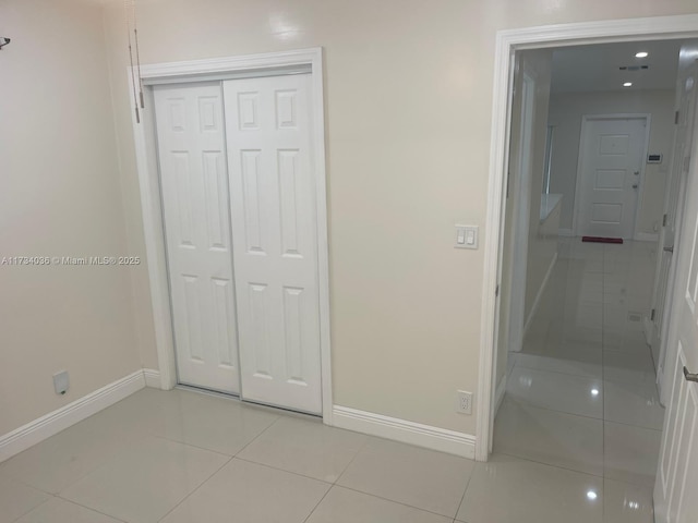 unfurnished bedroom with light tile patterned flooring and a closet