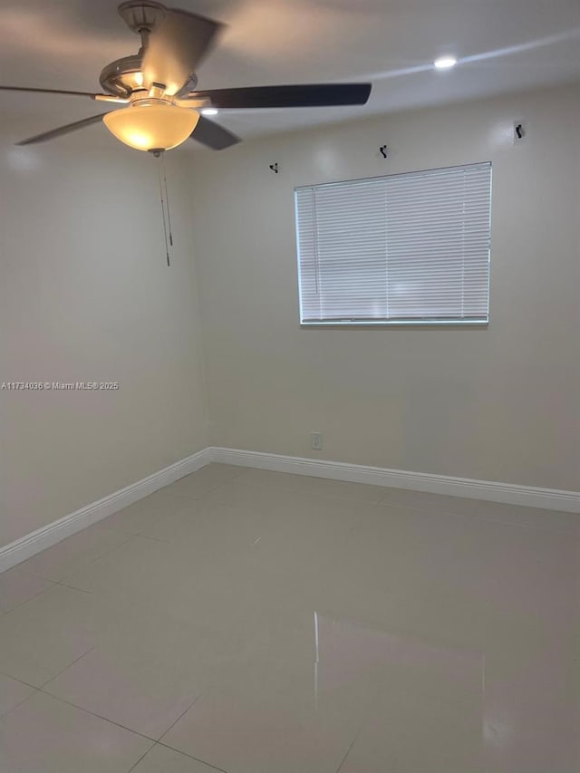 tiled spare room with ceiling fan