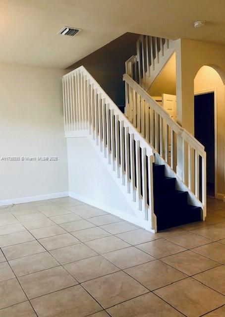 stairway with tile patterned flooring