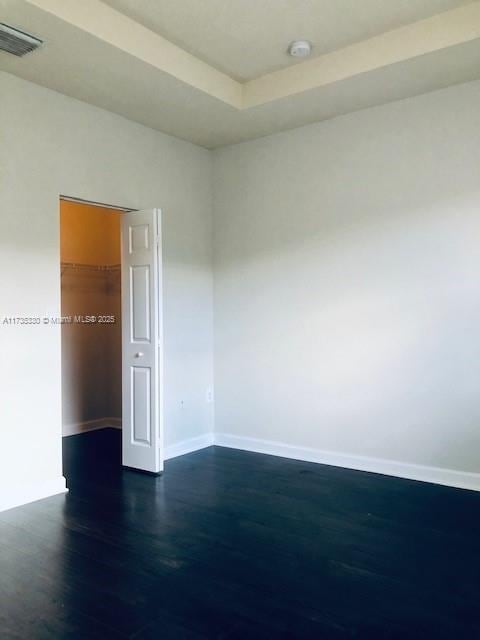 empty room with dark hardwood / wood-style flooring