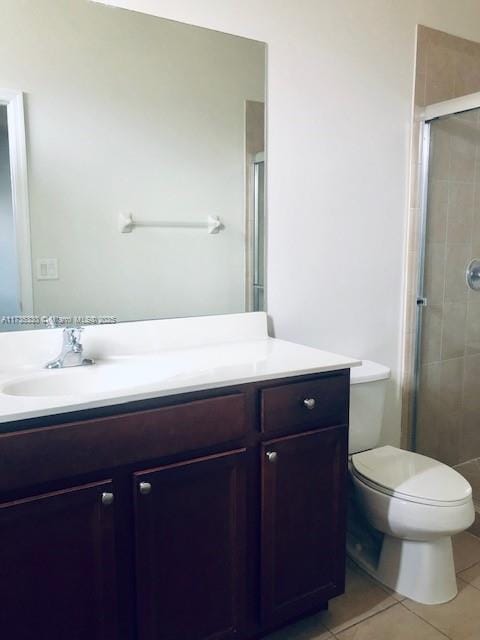 bathroom with walk in shower, tile patterned floors, toilet, and vanity