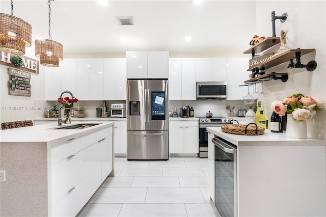 kitchen featuring wine cooler, tasteful backsplash, hanging light fixtures, appliances with stainless steel finishes, and white cabinets