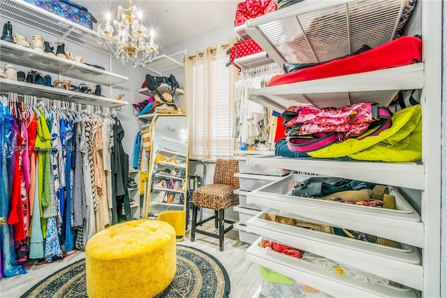 walk in closet with a notable chandelier