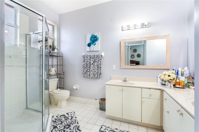 bathroom with vanity, a shower with shower door, tile patterned floors, and toilet