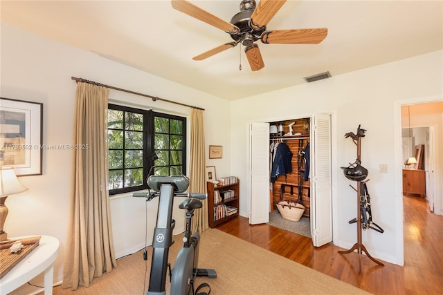 exercise area featuring ceiling fan and wood-type flooring