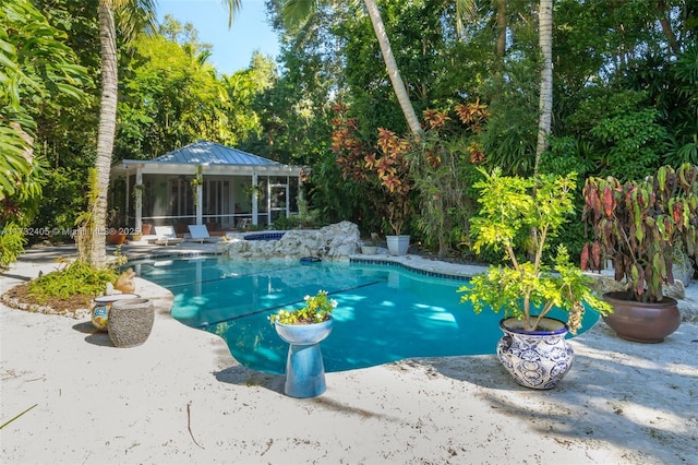 view of swimming pool featuring a sunroom