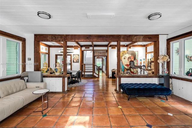 living room featuring tile patterned flooring and beamed ceiling