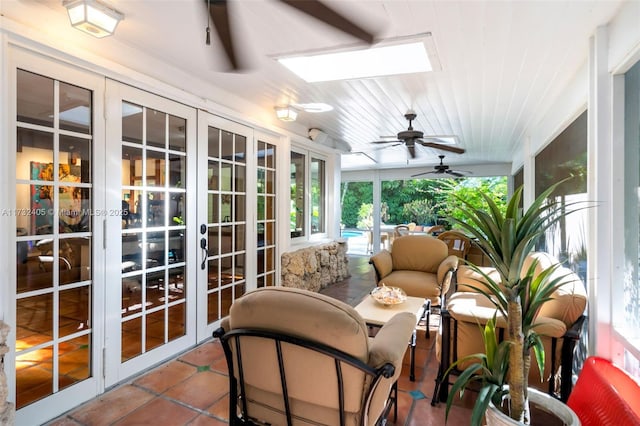 sunroom featuring wooden ceiling, ceiling fan, and a skylight