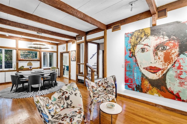 living room with beamed ceiling and light hardwood / wood-style floors