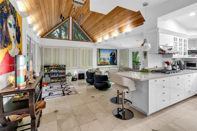 kitchen featuring decorative light fixtures, stainless steel gas stovetop, white cabinets, kitchen peninsula, and wooden ceiling