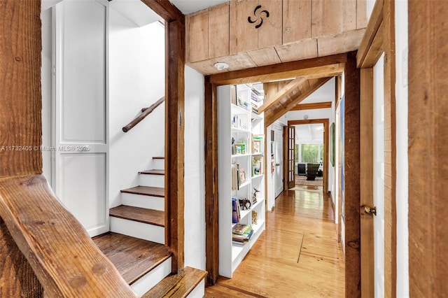 stairway featuring wood-type flooring and beam ceiling