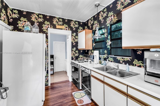 kitchen with sink, black dishwasher, white refrigerator, white cabinets, and gas range