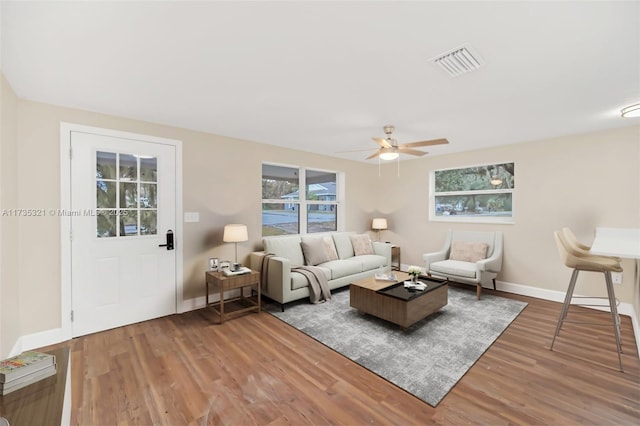 living room with wood-type flooring and ceiling fan