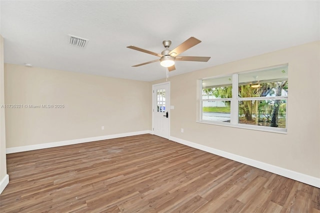 empty room with ceiling fan and hardwood / wood-style floors