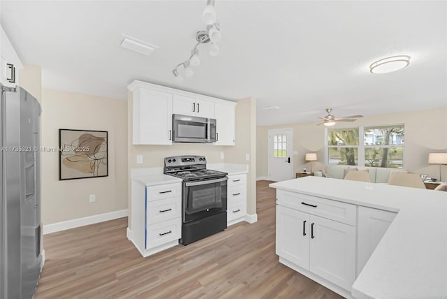 kitchen with white cabinetry, appliances with stainless steel finishes, ceiling fan, and light hardwood / wood-style floors