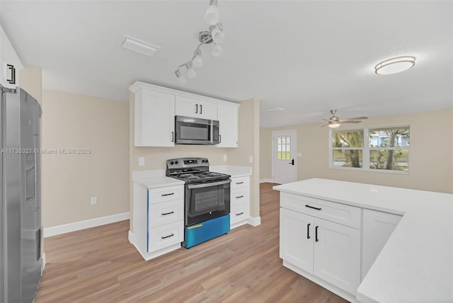 kitchen featuring stainless steel appliances, white cabinets, and light wood-type flooring