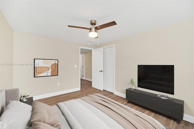 bedroom with hardwood / wood-style floors, ceiling fan, and a closet