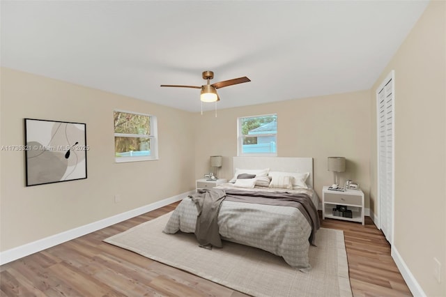 bedroom featuring ceiling fan, wood-type flooring, and multiple windows