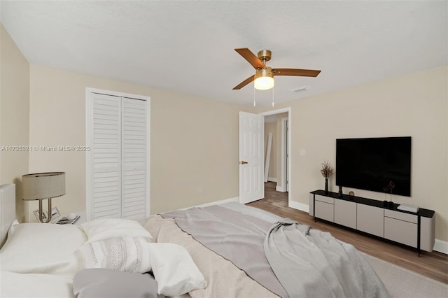 bedroom with ceiling fan, wood-type flooring, and a closet