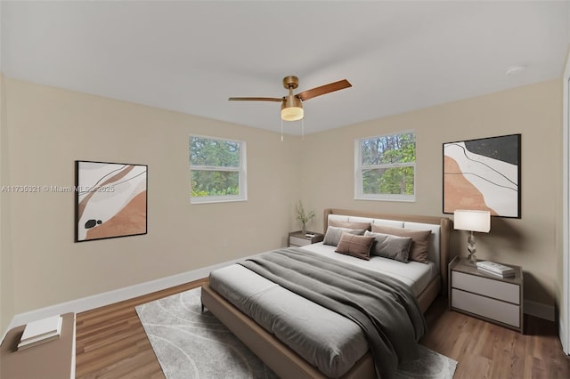 bedroom featuring multiple windows, light hardwood / wood-style floors, and ceiling fan