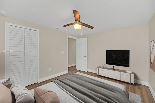 bedroom featuring wood-type flooring, a closet, and ceiling fan