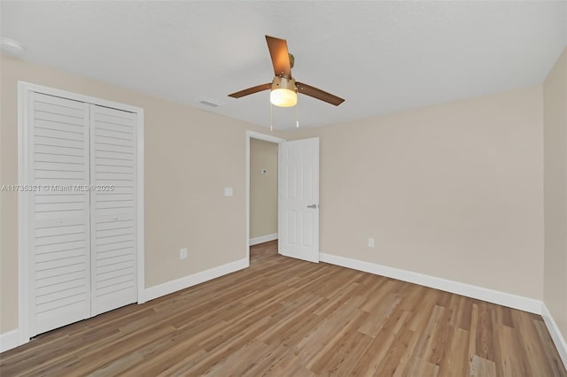 unfurnished bedroom with ceiling fan, hardwood / wood-style floors, and a closet