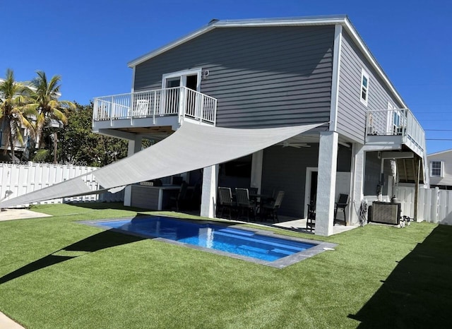 back of property with central AC unit, a yard, a patio, and a balcony