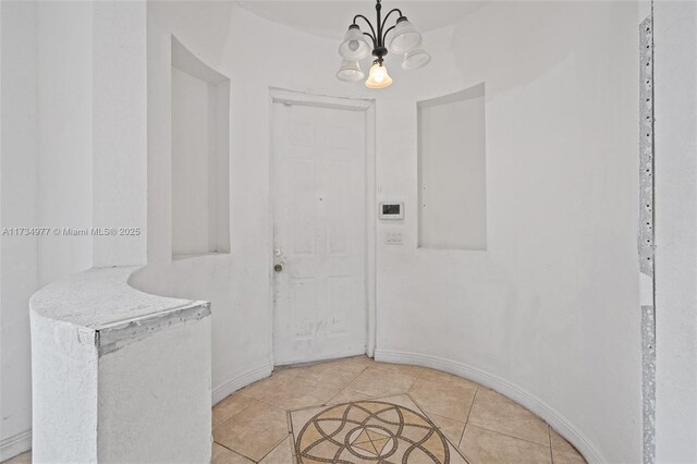 tiled entrance foyer featuring a chandelier