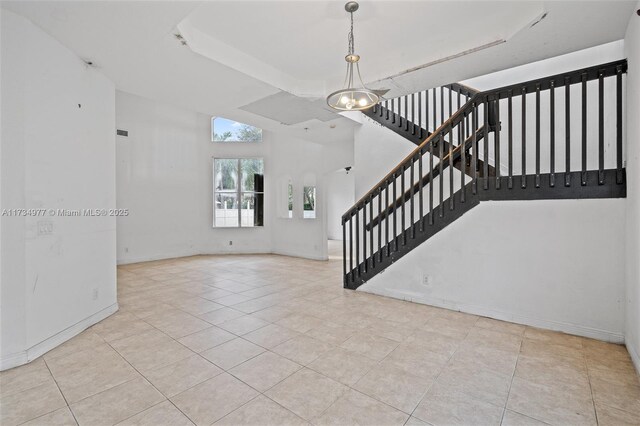 interior space with a high ceiling and light tile patterned flooring